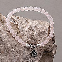 Rose quartz beaded stretch bracelet, 'Still Rose' - Rose Quartz and Flower Charm Beaded Bracelet from Bali