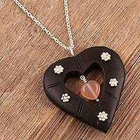 Rose quartz pendant necklace, 'Blossoming Romance' - Rose Quartz and Ebony Wood Heart-Themed Pendant Necklace