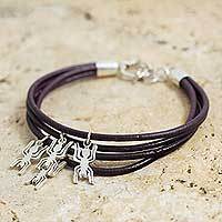 Sterling silver and leather charm bracelet,