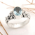 Blue topaz single stone ring, 'Frangipani Path' - Oval Cut Blue Topaz and Silver Ring with Floral Design