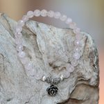 Rose quartz beaded stretch bracelet, 'Still Rose' - Rose Quartz and Flower Charm Beaded Bracelet from Bali