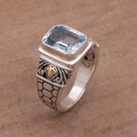 Gold accented blue topaz single stone ring, 'Blue Extravaganza' - Handmade Blue Topaz Single Stone Ring with Gold Accents