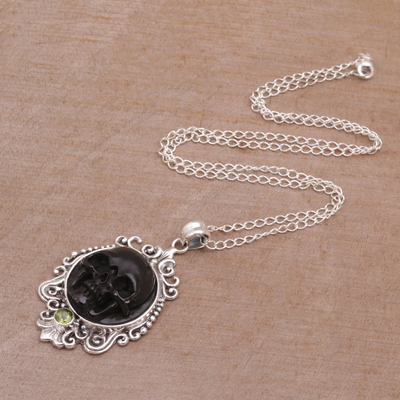 Peridot pendant necklace, 'Skull Stare in Black' - Peridot and Bone Black Skull Pendant Necklace from Bali