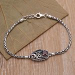 Garnet and blue topaz pendant bracelet, 'Crashing Waves' - Sterling Silver Blue Topaz and Garnet Pendant Bracelet