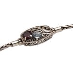 Garnet and blue topaz pendant bracelet, 'Crashing Waves' - Sterling Silver Blue Topaz and Garnet Pendant Bracelet