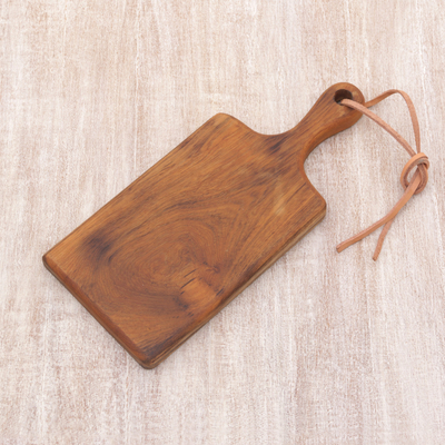 Teak wood cutting board, 'Dinner Party' - Teak Wood and Leather Accent Handcrafted Cutting Board