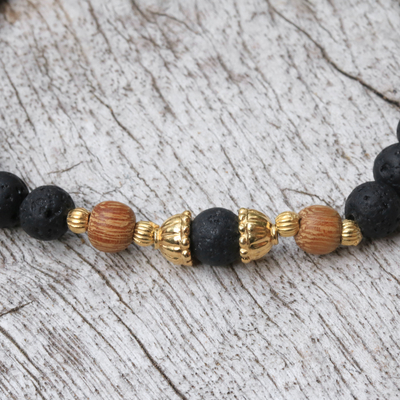 Gold accent lava stone beaded stretch bracelet, 'Batuan Tune' - Lava Stone Bracelet with Gold Plated Beads