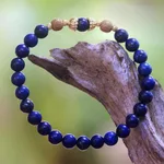 Gold accented lapis lazuli beaded stretch bracelet, 'Batuan Tune' - Gold Accented Lapis Lazuli Beaded Stretch Bracelet from Bali