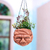 Coconut shell hanging planter, 'Cheesy Grin' - Artisan Crafted Coconut Shell Hanging Planter