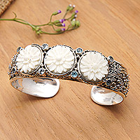 Blue topaz cuff bracelet, 'Loyal Lotus for Brahma' - Lotus-Themed Sterling Silver and Blue Topaz Cuff Bracelet