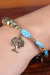 Resin and brass beaded charm bracelet, 'Tree of Calm' - Brass and Turquoise-Toned Resin Beaded Tree Charm Bracelet