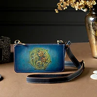 Leather sling bag, 'Teal Circle of Blossoms' - Floral-Themed Embossed Leather Sling with Removable Strap