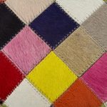 Cowhide ottoman cover, 'Festive Checkerboard' - Circular Handcrafted Hair-on Cowhide Patchwork Ottoman Cover