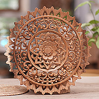 Holzreliefplatte, „Sun Bloom“ – handgeschnitzte kreisförmige Suar-Holzreliefplatte mit Blumenmuster aus Bali
