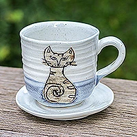 Ceramic cup and saucer, 'Whimsical Cat' - Handcrafted Ceramic Cup and Saucer Set with Cat Motif