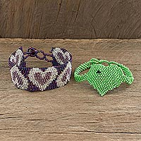 Beaded wristband friendship bracelets, 'Hearts in Purple and Green' (pair) - Guatemalan Handcrafted Beaded Friendship Bracelets (Pair)
