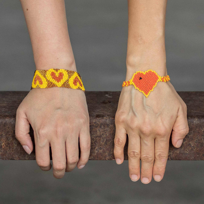 Beaded wristband friendship bracelets, 'Hearts in Orange' (pair) - Yellow and Orange Heart Beaded Friendship Bracelets (Pair)