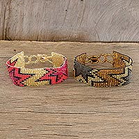 Beaded wristband friendship bracelets, 'Twin Stars in Gold and Black' (pair) - Handmade Glass Beaded Wristband Friendship Bracelets (Pair)