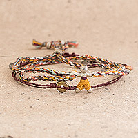 Braided cord bracelets, 'Multicolor Maize Man' (pair) - Braided Cord Bracelet with Corn Man Pendant from Guatemala