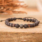 Men's hematite and volcanic stone beaded bracelet, 'Inner Protector' - Men's Volcanic Stone Beaded Bracelet with Hematite Jewel