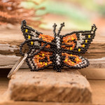 Glass beaded keychain, 'Fluttering Hopes' - Handcrafted Black and Orange Glass Beaded Butterfly Keychain