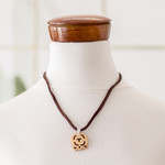 Coconut shell and lava stone pendant necklace, 'Strength and Renewal' - Coconut Shell and Lava Stone Iq' Sign Pendant Necklace