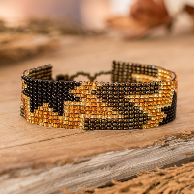 Beaded wristband bracelet, 'Heroic Blast' - Artisan-Made Black and Bronze Star Glass Beaded Bracelet