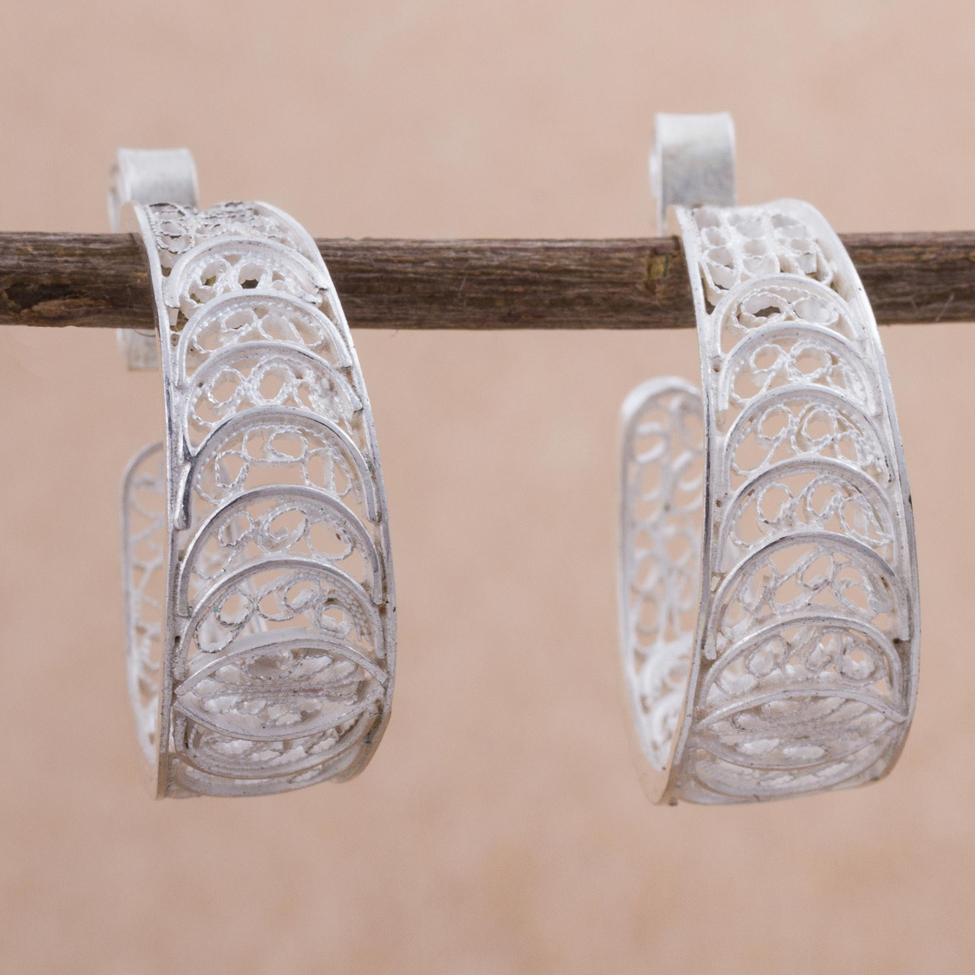 Featuring handcrafted sparkling filigree motifs in silver, the earrings are...