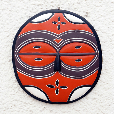 Afrikanische Holzmaske - Kreisförmige orangefarbene afrikanische Maske, von Hand in Ghana geschnitzt
