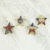 Wood ornaments, 'Nsruma Pride' (set of 4) - Four Sese Wood Star Ornaments in Red Blue and Beige
