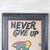 Wood wall art, 'Never Give Up' - Inspirational Wood Wall Art with a Leather Frame from Ghana
