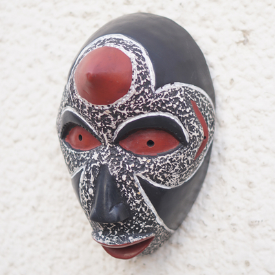 Afrikanische Holzmaske - Handgefertigte afrikanische Sese-Holzmaske in Schwarz- und Rottönen
