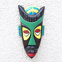 Afrikanische Holzmaske, „Omnipresence“ – handbemalte afrikanische Holzmaske in Schwarz, Grün, Gelb und Rot