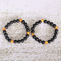 Recycled glass beaded stretch bracelets, 'Galaxy Glam' (pair) - Two Black and Yellow Recycled Glass Beaded Stretch Bracelets