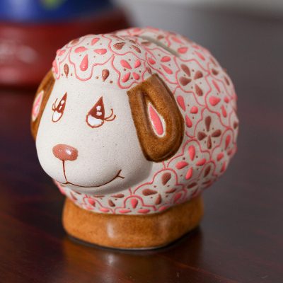 Dot piggy bank in earthenware with pink accents.