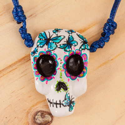 Hand painted pendant necklace, 'Blue Butterfly Calavera' - Hand Painted Skull Necklace with Butterflies