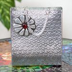 Aluminum repousse decorative box, 'Hearts and Flower' - Aluminum Gift Bag-Shaped Decorative Container with Flower