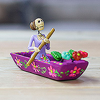 Keramikfigur, „River Catrina in Mulberry“ – handbemalte Catrina auf einem Boot, Keramikfigur in Lila
