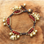 Carnelian charm bracelet, 'Fortune's Melody' - Elephant and Bell Charm Bracelet in Carnelian and Brass thumbail