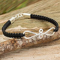 Leather and sterling silver braided bracelet, 'Black Infinity Swirl' - Thai Black Leather Braided Bracelet with Sterling Silver