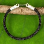 Braided leather bracelet, 'Elephant Promise in Black' - Braided Leather Cord Bracelet with Silver Elephant Clasp