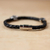 Men's braided leather bracelet, 'Midnight Rays' - Men's Braided Leather Bracelet with Stainless Steel Accents