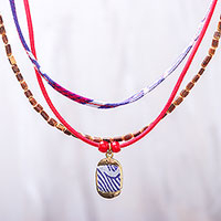 Halskette mit Anhänger aus Baumwolle und Holzperlen, „Joyful Jumble“ – Halskette mit Anhänger aus vielen Strängen aus blauem und rotem Holz, Baumwolle und Messing