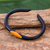 Leather cuff bracelet, 'Black-Orange Eye' - Black and Orange Leather Cuff Bracelet from Thailand